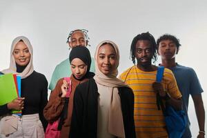 In a vibrant display of educational diversity, a group of students strikes a pose against a clean white background, holding backpacks, laptops, and tablets, symbolizing a blend of modern technology photo