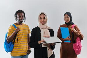 A group of students, including an African American student and two hijab-wearing women, stand united against a pristine white background, symbolizing a harmonious blend of cultures and backgrounds in photo