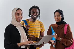 A group of students, including an African American student and two hijab-wearing women, stand united against a pristine white background, symbolizing a harmonious blend of cultures and backgrounds in photo