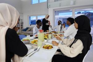 In the sacred month of Ramadan, a Muslim family joyously comes together around a table, eagerly awaiting the communal iftar, engaging in the preparation of a shared meal, and uniting in anticipation photo