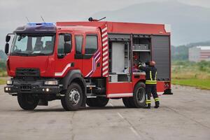 A firefighter meticulously prepares a modern firetruck for a mission to evacuate and respond to dangerous situations, showcasing the utmost dedication to safety and readiness in the face of a fire photo