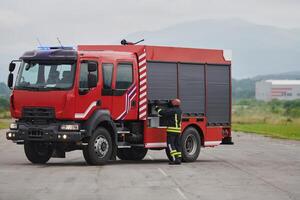 A firefighter meticulously prepares a modern firetruck for a mission to evacuate and respond to dangerous situations, showcasing the utmost dedication to safety and readiness in the face of a fire photo