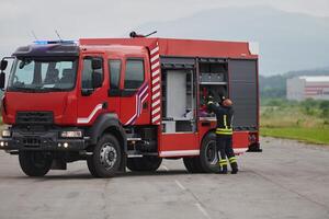 A firefighter meticulously prepares a modern firetruck for a mission to evacuate and respond to dangerous situations, showcasing the utmost dedication to safety and readiness in the face of a fire photo