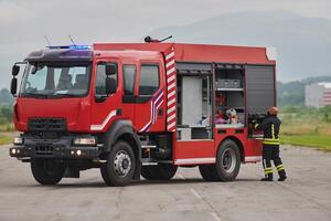 A firefighter meticulously prepares a modern firetruck for a mission to evacuate and respond to dangerous situations, showcasing the utmost dedication to safety and readiness in the face of a fire photo