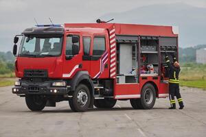 A firefighter meticulously prepares a modern firetruck for a mission to evacuate and respond to dangerous situations, showcasing the utmost dedication to safety and readiness in the face of a fire photo