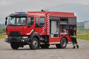 A firefighter meticulously prepares a modern firetruck for a mission to evacuate and respond to dangerous situations, showcasing the utmost dedication to safety and readiness in the face of a fire photo
