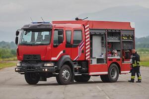 A firefighter meticulously prepares a modern firetruck for a mission to evacuate and respond to dangerous situations, showcasing the utmost dedication to safety and readiness in the face of a fire photo