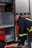 A firefighter meticulously prepares a modern firetruck for a mission to evacuate and respond to dangerous situations, showcasing the utmost dedication to safety and readiness in the face of a fire photo