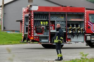 A firefighter meticulously prepares a modern firetruck for a mission to evacuate and respond to dangerous situations, showcasing the utmost dedication to safety and readiness in the face of a fire photo