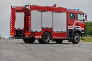 In this captivating scene, a state-of-the-art firetruck, equipped with advanced rescue technology, stands ready with its skilled firefighting team, prepared to intervene and respond rapidly to photo