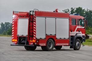In this captivating scene, a state-of-the-art firetruck, equipped with advanced rescue technology, stands ready with its skilled firefighting team, prepared to intervene and respond rapidly to photo