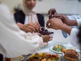 A woman in a hijab extends a platter of dates to her diverse family, creating a scene of unity and joy as they come together to break their fast during the holy month of Ramadan, symbolizing the photo