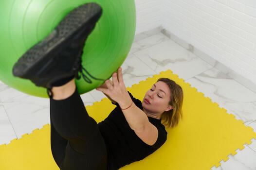 joven deportivo hembra atleta hacer ejercicio con aptitud pelota a hogar foto