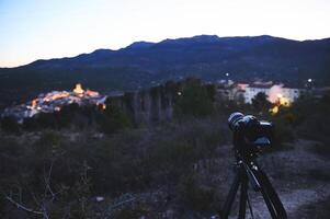 Digital camera placed on tripod, capturing the medieval village of Quesada in mountains Sierra de Cazorla at sunrise. Blurred mountains on the background. Travel photography. World photography Day photo