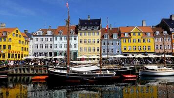 COPENHAGEN, DENMARK, APRIL 27, 2024 Copenhagen iconic view. The popular Nyhavn port area with the colorful houses in the center of Copenhagen, Denmark during spring season sunny day photo