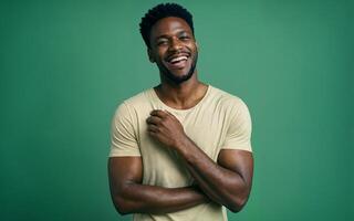 Confident African man laughing while standing against green background photo