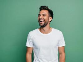 Confident man wearing white tshirt laughing while standing against aqua background photo
