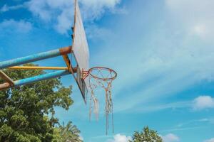 View of an old basketball hoop in the sky from a low angle photo