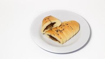 Traditional Indonesian snack called, chocolate banana bread which is bread filled with banana and chocolate jam served on a plate isolated on a white background photo