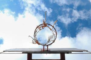 View of an old basketball hoop in the sky from a low angle photo