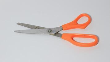 Light orange scissors on white background photo