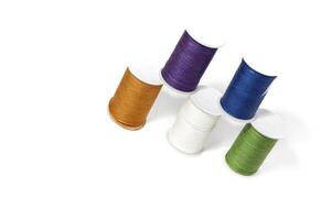 Spool of sewing thread, isolated on white background. Colored yarns used by factories in the clothing industry. Threads wound on the spool. Colored reels photo