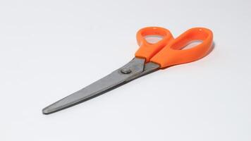 Light orange scissors on white background photo