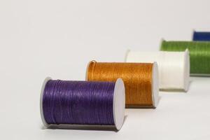 Spool of sewing thread, isolated on white background. Colored yarns used by factories in the clothing industry. Threads wound on the spool. Colored reels photo