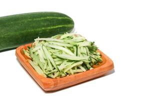 Grated cucumber in a bowl on white background. Healthy vegetarian ingredients photo