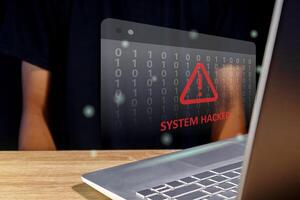 Hacker or cyber criminal with laptop stealing user personal data. Warning of a system hacked. Virus, malware or cyber attack. photo