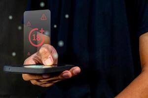 Man holding a smart phone with restricted content for mature audience on virtual screen photo