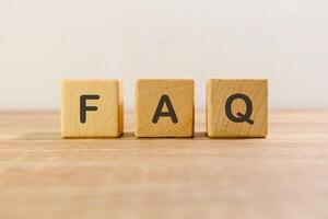 Frequently asked questions or FAQ written on wooden blocks photo