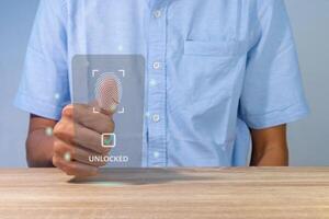 A man unlock and access to personal data by scanning fingerprint on virtual screen photo