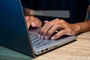 A man using a laptop to searching for information. Search engine optimization concept. photo