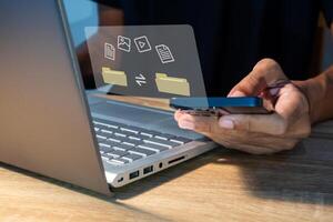 File transfer between mobile phone and laptop. Copy file and media or exchange data on virtual screen. photo