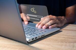 Man using laptop to download media or update software. Downloading process bar on virtual screen. photo