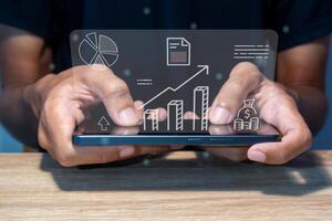 A man analyzing growth sales data graph on virtual screen and making trading online photo