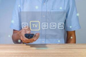 A man using a smart TV remote to change and control the entertainment menu photo