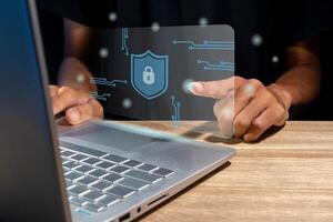 Man using a laptop with virtual screen of cyber security technology for protecting personal data and secure internet access concept. photo