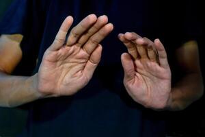 Man give signs of fear and rejection on dark background. Gesturing Stop or rejecting something. photo