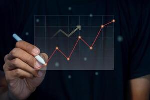 A man holding a pen with virtual screen of investment financial chart. Growth and successful concept. photo