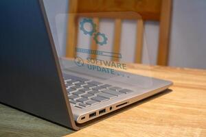 Software system update process concept. A laptop on the table with updating progress bar on virtual screen. photo