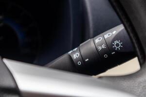 Close up view of car light switch control. Headlight switch, turn signal lever, and fog light switch. photo