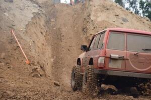 a red SUV in the mud accelerates to overcome obstacles. Off-road competition for SUVs. photo