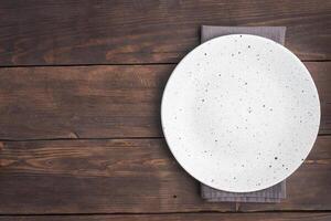 Empty white plate on wooden rustic background. Top view with copy space. photo