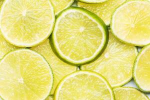 Slices of ripe juicy lime. Green background of citrus lime. photo