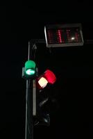traffic light with a green arrow pointing left, a red light, and a digital countdown timer displaying 11. The scene is dark and quiet, with a sense of anticipation. photo