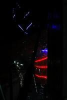 blurry view of a taillights through a windshield. The taillights are red and blue, and the windshield is covered in raindrops photo