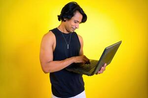 Man using laptop against yellow background photo