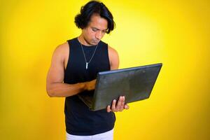 Man intently looking at a laptop he holding photo